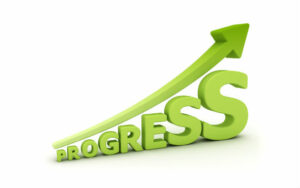 The word progress in green text with an arrow pointing upwards