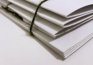 Close up photo of some white paper folders bound together with dark twine
