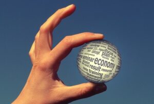 A white ball with many words written on it held between someone's thumb and forefinger