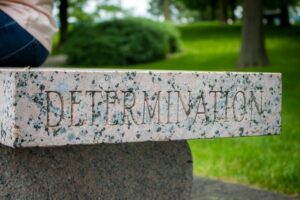 Granite/Stone bench seat in a park with the word 'determination' engraved on the side edge.