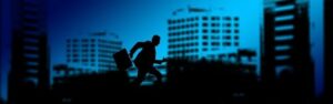 Silhouette of a suited man carrying a briefcase and running between office buildings