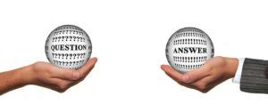 Two hands with a transparent ball cupped in each, one with the word Question and the other Answer; for Ask the Expert: How can team spirit be improved when working remotely?