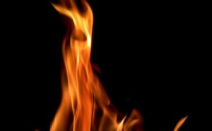 A flickering flame against a dark, black background