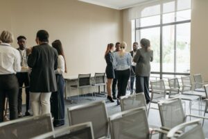 Photo of two groups of people standing in separate circles talking in a training room