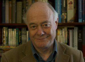 Photograph of Dr David Mason Brown in front of a full bookcase