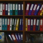 Photo of a colourful assortment of labelled files on shelves for resources for wellbeing at work newsletter