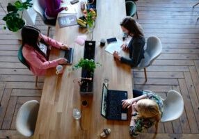 Wellbeing and Resilience in the Workplace - a group of women working together around a shared desk